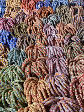 Heaps of strung Krobo glass beads in many colours