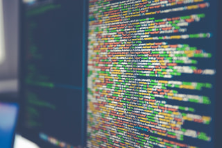 Lines of colourful code on a computer monitor, seen at an angle